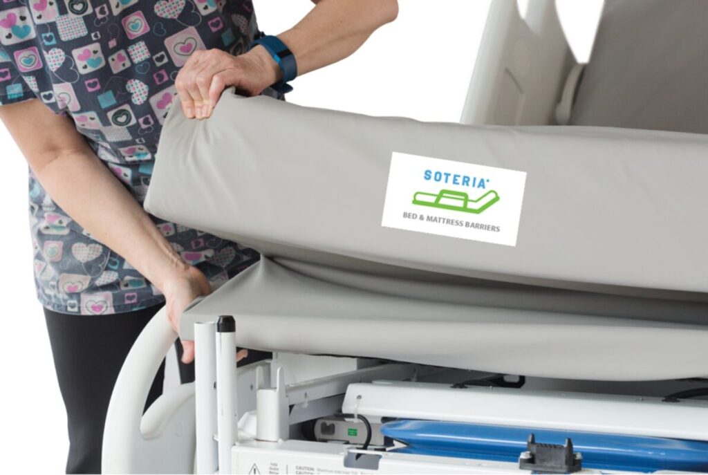 A clinician applying a Trinity Guardion Soteria bed and mattress barrier to a hospital bed
